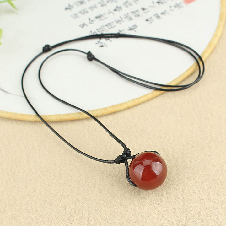 Collana con ciondolo in corda di pelle con perline di agata rossa e Buddha Stones