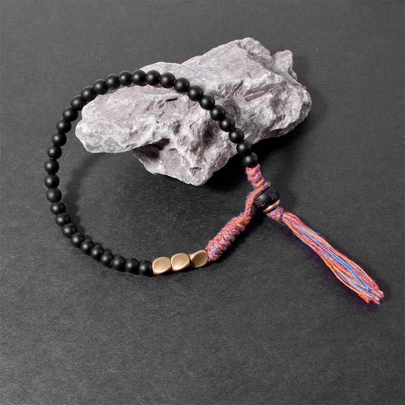 Braccialetto fatto a mano in onice nero tibetano con nappa Buddha Stones