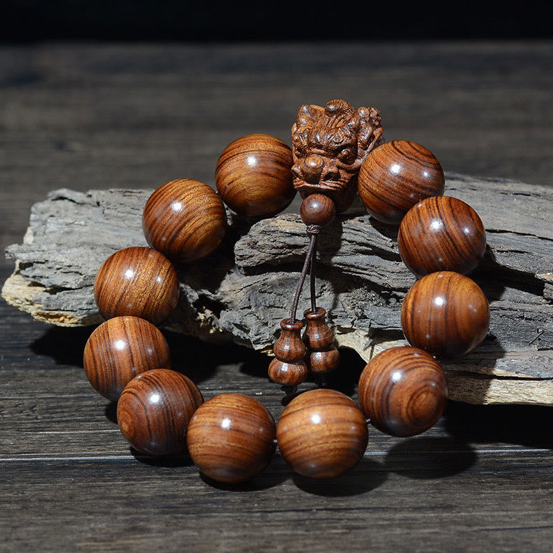 Braccialetto di protezione intagliato a forma di drago con piccole foglie di sandalo rosso, in palissandro e sandalo verde Buddha Stones