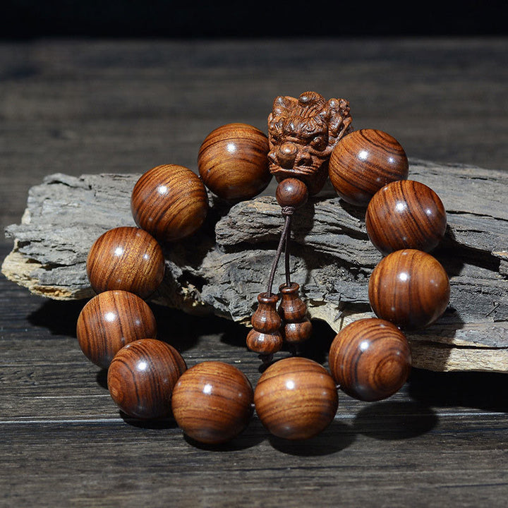 Braccialetto di protezione intagliato a forma di drago con piccole foglie di sandalo rosso, in palissandro e sandalo verde Buddha Stones