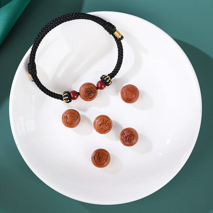 Braccialetto della ricchezza in cinabro intagliato con carattere dello zodiaco cinese Fu in legno di pesca naturale Buddha Stones