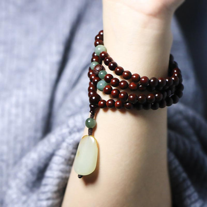 Braccialetto di meditazione Mala in giada di sandalo rosso con piccole foglie tibetane di Buddha Stones