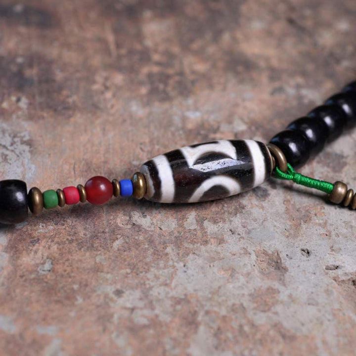 Buddha Stones 108 Perline Mala Legno di Ebano Dzi Perline Rame Braccialetto con Nappa