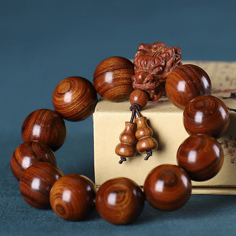 Braccialetto di protezione intagliato a forma di drago con piccole foglie di sandalo rosso, in palissandro e sandalo verde Buddha Stones