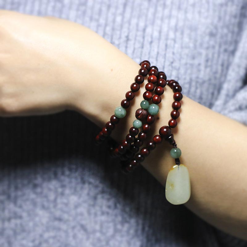 Braccialetto di meditazione Mala in giada di sandalo rosso con piccole foglie tibetane di Buddha Stones