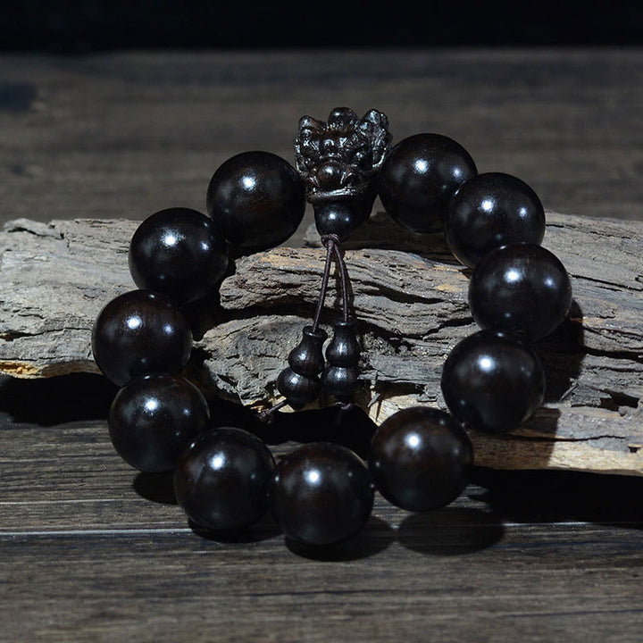 Braccialetto di protezione intagliato a forma di drago con piccole foglie di sandalo rosso, in palissandro e sandalo verde Buddha Stones