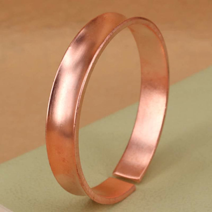 Bracciale rigido in rame con simbolo di ricchezza e fortuna