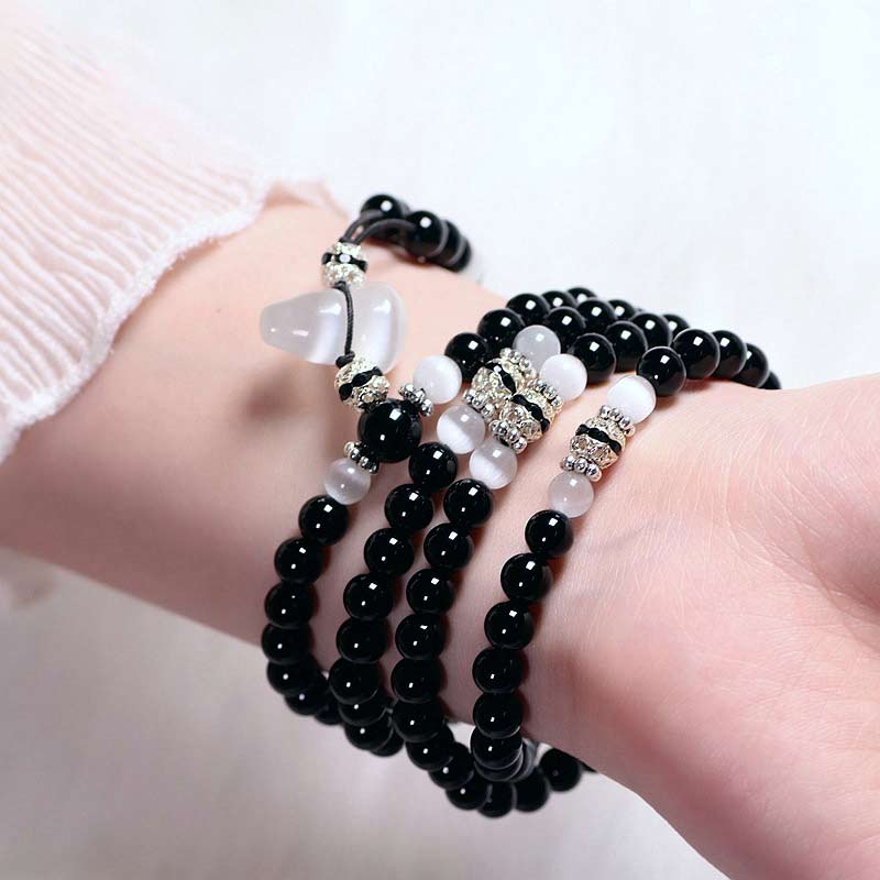 Braccialetto di meditazione con perline di cristallo bianco e onice nero Buddha Stones