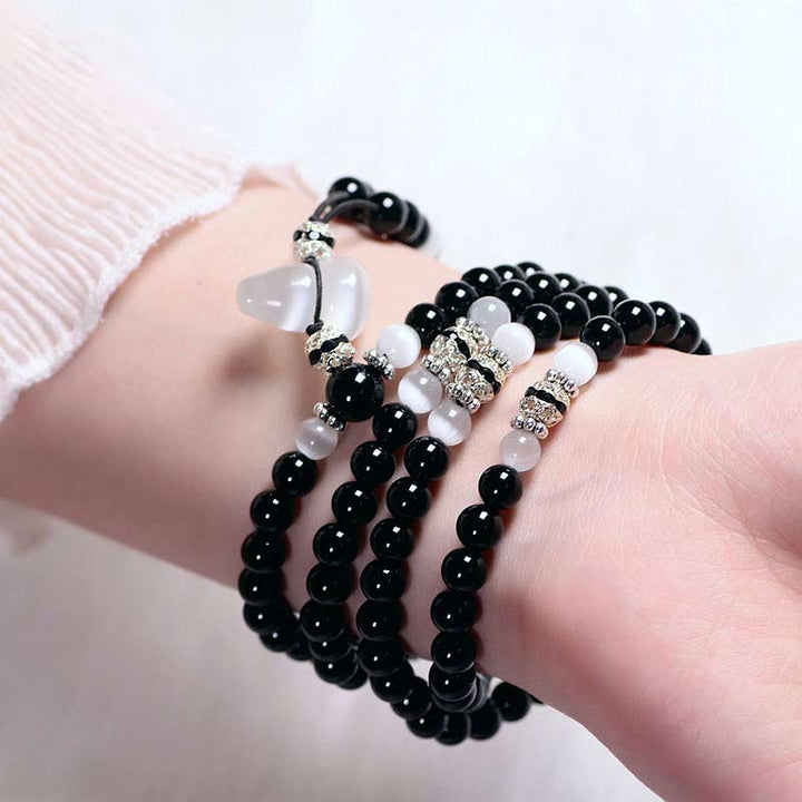 Braccialetto di meditazione con perline di cristallo bianco e onice nero Buddha Stones
